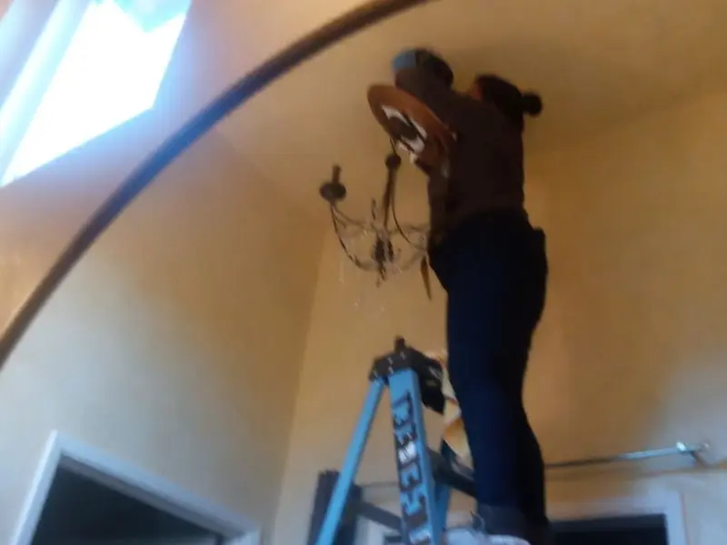 Electrician installing a chandelier in a Wickenburg residence